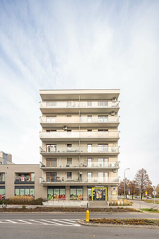 Budynek mieszkalny w Warszawie z supermarketem Biedronka na parterze.