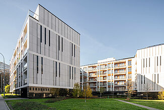 Budynek mieszkalny Piano House w Warszawie z zielonym wewnętrznym dziedzińcem i ławkami.