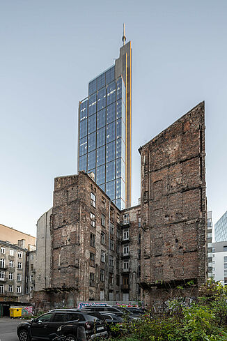 Na pierwszym planie widać zrujnowany budynek, a za nim Varso Tower w Warszawie.