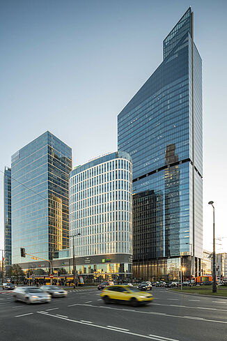 Widok przez ruchliwą drogę na Skyliner Tower w Warszawie.