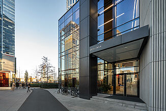 Przeszklone wejście do wieżowca Skyliner Tower w Warszawie.