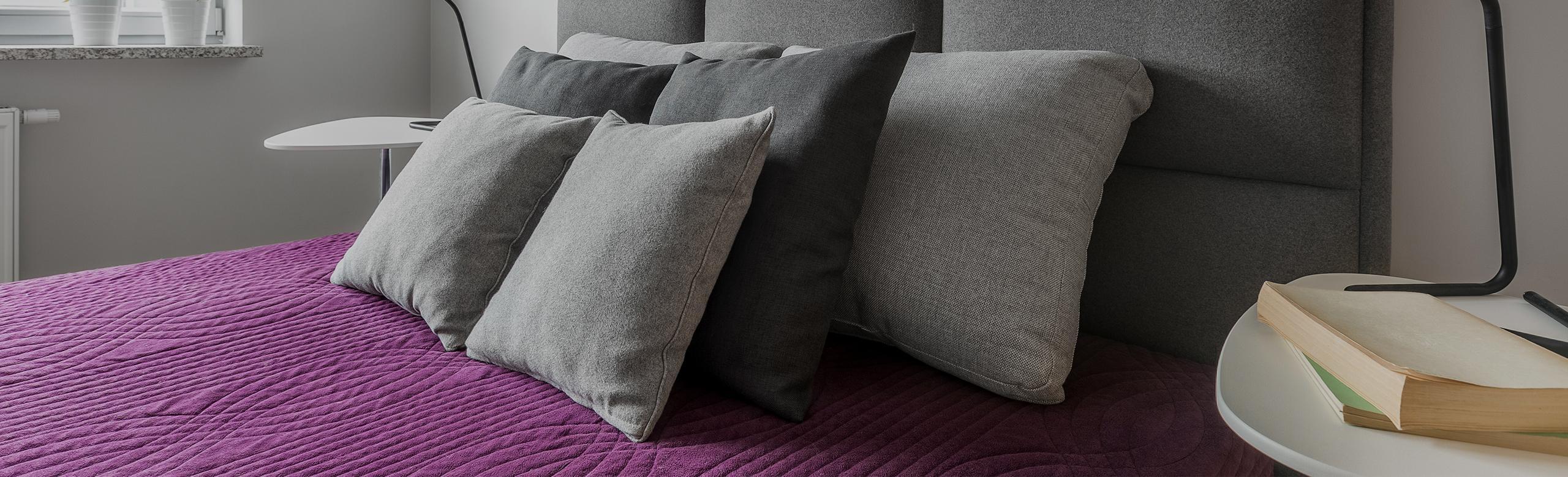 Łóżko z materacem sprężynowym w pokoju hotelowym.