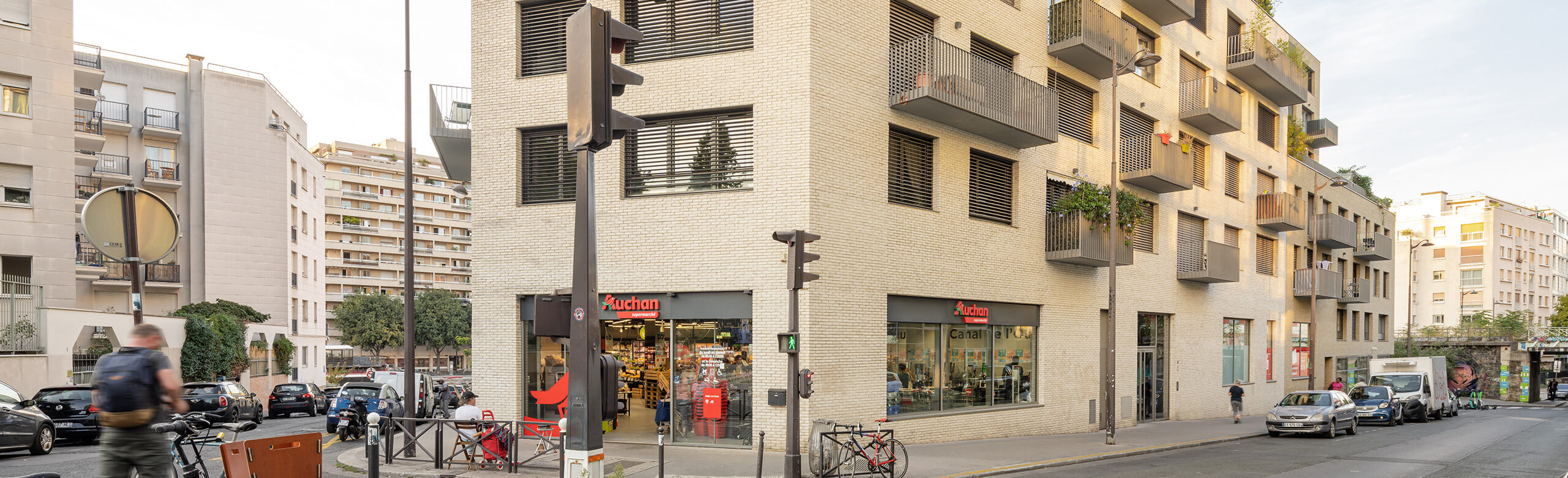 A mixed-use building in Paris with an Auchan supermarket on the ground floor and flats above.