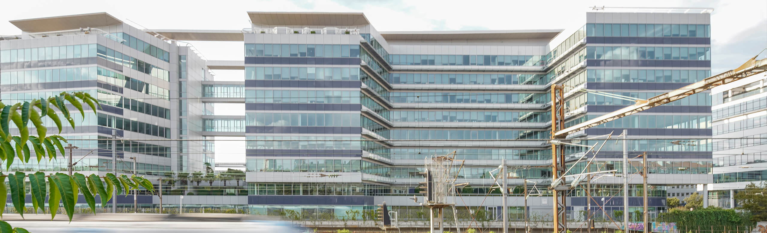 Imposing West Plaza office complex with railway infrastructure in front.
